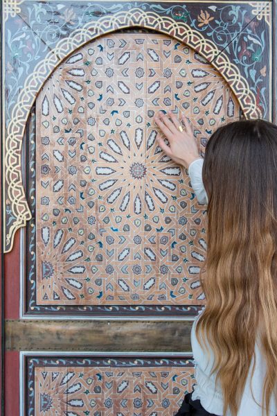 Personne qui touche la mosaïque du Jardin Secret de Marrakech